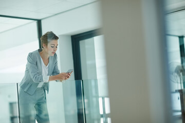 Fototapeta premium Phone, reading or businesswoman in hallway for planning, email response or confirm schedule online. Review, digital to do list update or employee with mobile for notes app, admin message or internet