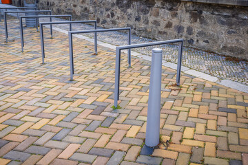 Empty metal bicycle racks line a modern city street