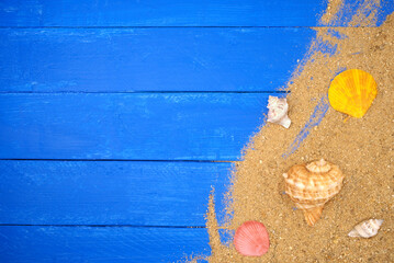Seashells and sand on blue wooden. Sea summer vacation background with space for the text. Top view