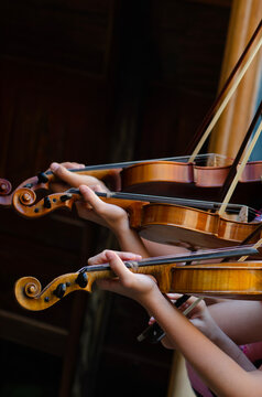 The children holding a violin and bow, practicing with dedication. A tender moment that highlights learning, discipline, and the joy of discovering music at an early age.