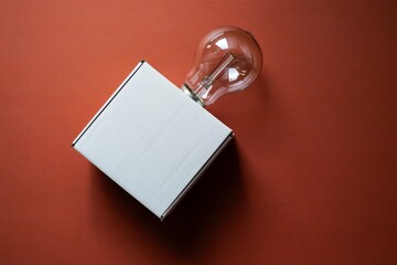 Close up of white cardboard box with industrial bulb on red background