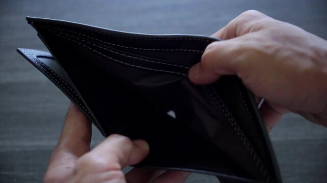 Hand holding an open wallet, showing the empty inside