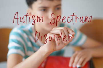 Autism Spectrum Disorder. Health and well-being in childhood and adolescence. Preteen boy writing text on the screen with a red marker.