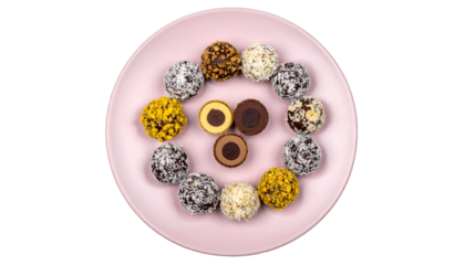 A top-down shot of a pink plate with a circular arrangement of colorful bite-sized sweets
