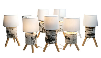 Seven table lamps. Birch log bases, white shades, wooden legs. Illuminated, isolated
