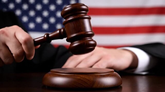 Gavel held over sounding block, American flag backdrop