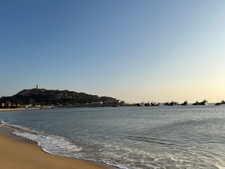 Coastal Harbor Scene with Boats and Distant Hills