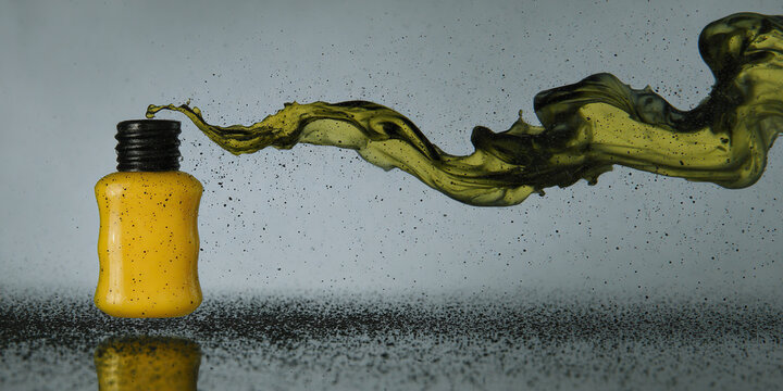Yellow bottle with black cap releasing a swirling stream of dark liquid and particles
