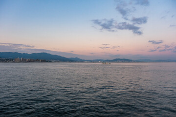 Obraz premium 夕暮れの宮島から眺める廿日市の市街地