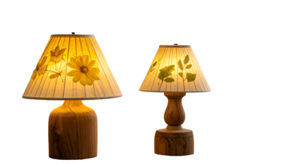 Two decorative lamps with floral shades and wooden bases glowing warmly against black