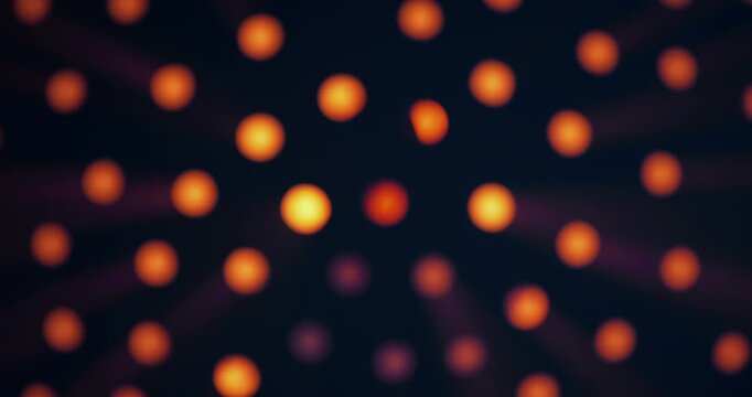 Warm yellow light shines through round holes in a black background. The intensity of the glow increases and decreases