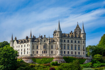 Fototapeta premium Dunrobin Castle overlooking Scottish Highlands coastline under blue sky