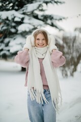 Young woman smiling in winter wonderland wearing warm clothes