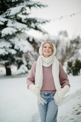 Smiling young woman enjoying winter leisure in snow