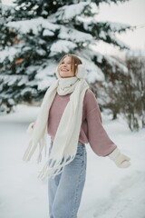 Young woman enjoying falling snow in winter park