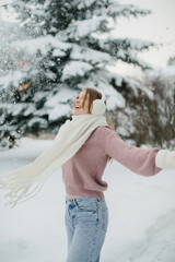 Young woman enjoying falling snow in winter park