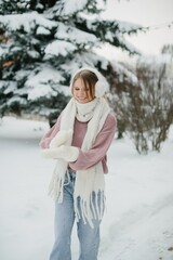 Happy young woman playing with snow in winter park