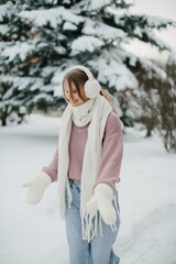 Young woman enjoying snowy winter day in warm clothing