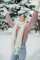 Woman enjoying winter day with arms raised