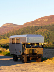 Off-road camper van exploring Scottish Highlands during golden hour