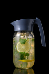Glass Pitcher with Refreshing Beverage on Black Surface