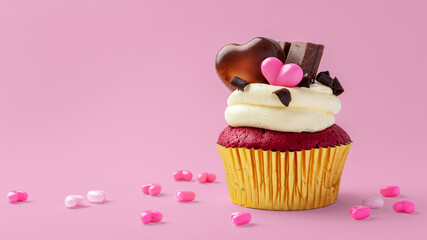 Red velvet cupcake decorated with heart chocolate and  pink hearts on pink background, valentines day and celebrating love concept