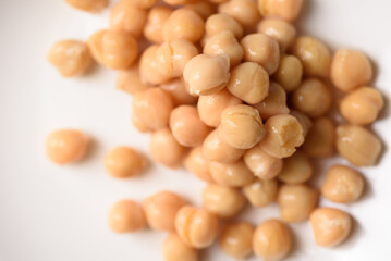 A close-up image of canned chickpeas placed on a white ceramic plate, ready for cooking