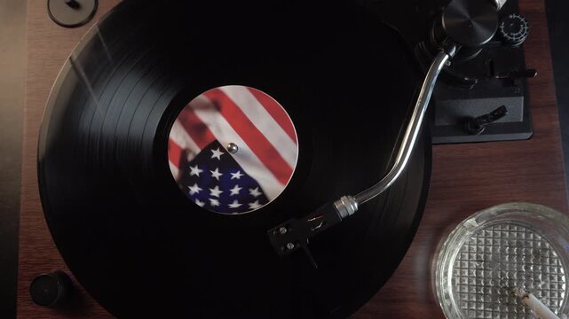 Listening Vinyl Record With American Flag Sticker, Cigarette in Ashtray, Top Down View