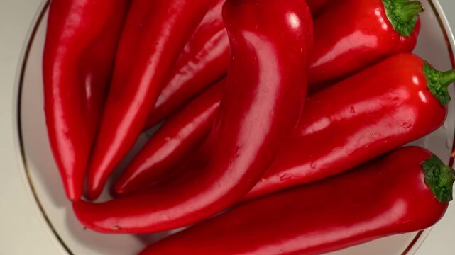 Premium quality red Capia sweet pepper rotating slowly on a deep black background. Glossy skin, elongated pointed shape, vibrant red color. Fresh organic pepper, healthy vegetable concept. Smooth 360-