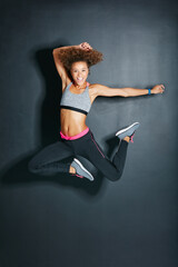 Dance, jumping and portrait of woman in dark studio for choreography, energy or fitness routine. Exercise, smile and space with hip hop dancer on black background for hobby, practice or rehearsal