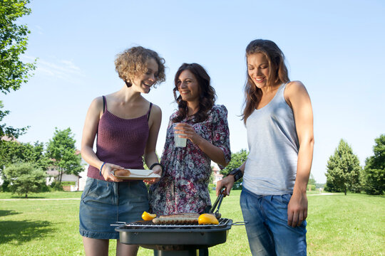 Friends grilling and enjoying leisure time outdoors in a park