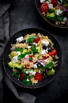 Mediterranean orzo salad with feta, black olives and fresh vegetables