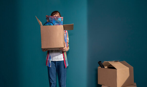 Woman holding cardboard box unpacking at home after moving