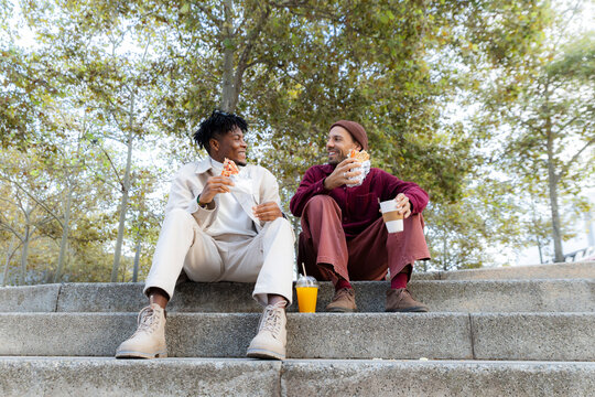 Friends enjoying casual lunch and conversation outdoors on park steps