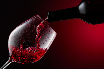 Red wine is poured from a bottle into a glass.