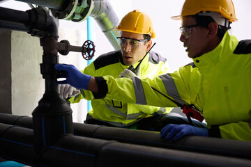 Engineers talking on walkie talkie and inspecting industrial pipelines, ensuring safety and...