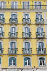 Yellow facade with small balconies in the old town of Lisbon, Portugal.
