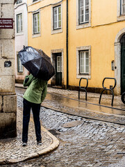 Woman with umbrella on a rainy day in the old town of Lisbon, Portugal.