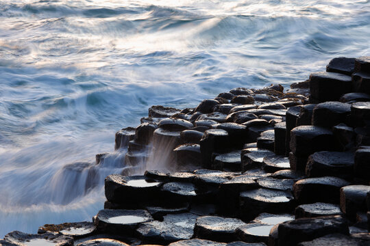 Hexagonal basalt columns of Giant's Causeway with crashing waves