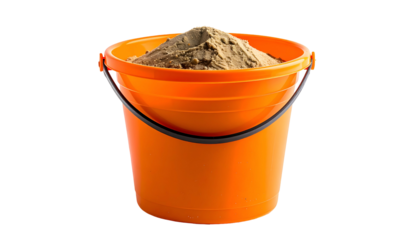 An orange bucket overflowing with tan sand against a black background