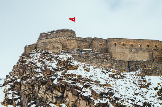 Kars Castle aerial view in winter with snow. Drone shot of historic medieval fortress on the hill in snowy weather in Turkey.