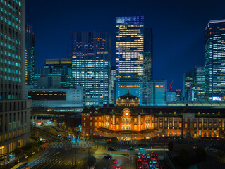Fototapeta premium Tokyo city night skyline with illuminated skyscrapers, office buildings, and Tokyo Station glowing in the Marunouchi business district of Chiyoda, Japan.