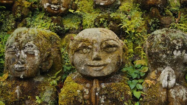 Moss covered buddhist rakan statues in a japanese temple