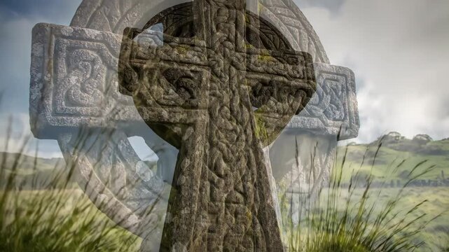 Ancient stone Celtic cross with intricate knot carvings in a green field. Weathered Irish high cross covered in moss and lichen under a cloudy sky. St. Patrick's Day concept