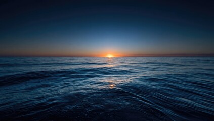 Beautiful ocean sunrise over a vast body of water, with sun rising on horizon