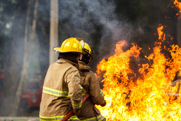 Firefighters extinguishing burning car during emergency response