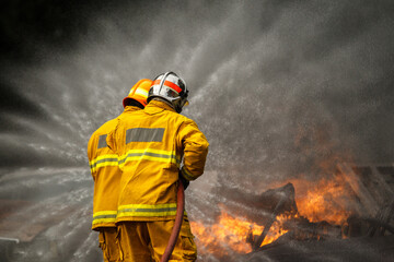 Firefighters extinguishing burning car during emergency response