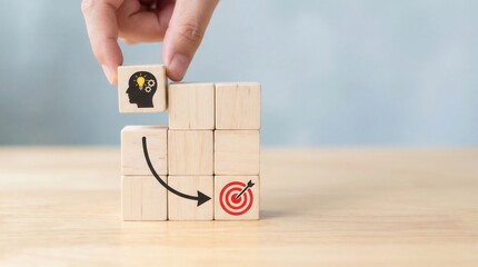 Hand places idea lightbulb gears block onto strategic path of wooden blocks leading to red target symbol on wood table for innovation strategy goal achievement