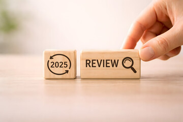 2025 Review Concept with Wooden Blocks and Hand