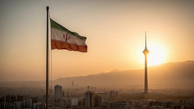 The Iranian flag rises above the city skyline at sunset